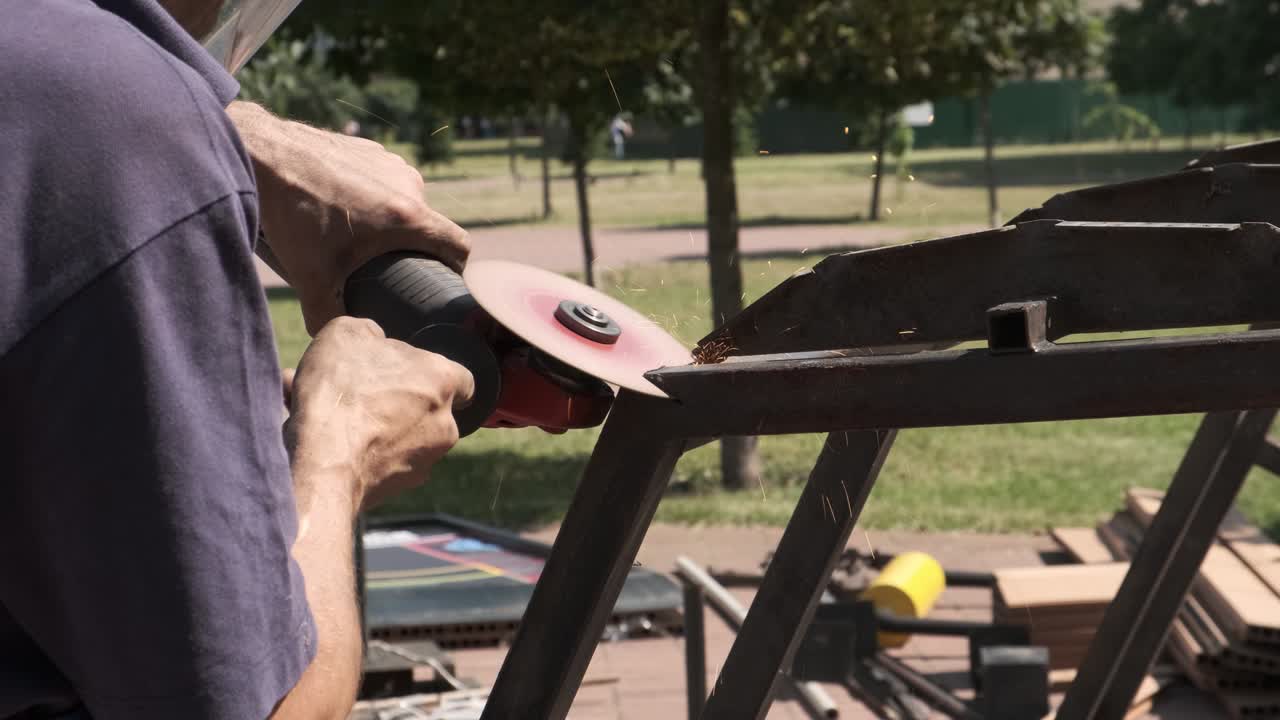 trabajador que utiliza un molinillo angular mientras trabaja en un taller industrial. chispas durante el corte de metal