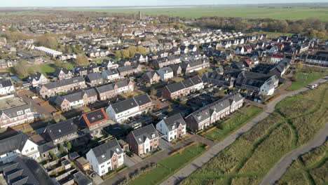 Aerial-of-a-modern-suburban-neighborhood-with-rooftops-filled-with-solar-panels---drone-slowly-revealing-rows-of-houses