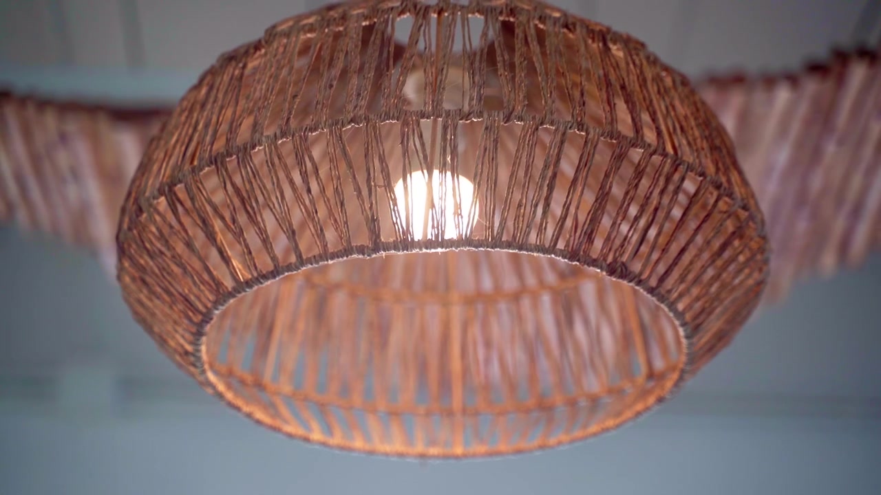 Flettet loftslampe med synlig pære, der svinger i luften
