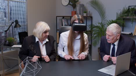 Woman wearing virtual reality glasses tries 3D app for VR helmet while colleagues supporting her