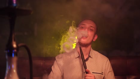 man smoking hookah in a lounge