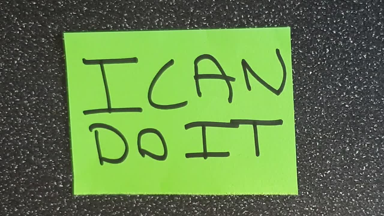 Man using scissors to remove the t from the word can't t leaving the positive motivational part. I can do it