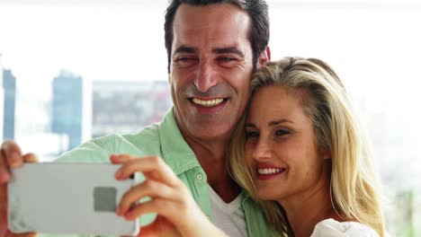 Lächelndes-Paar,-Das-Zu-Hause-Im-Wohnzimmer-Ein-Selfie-Vom-Mobiltelefon-Aus-Macht