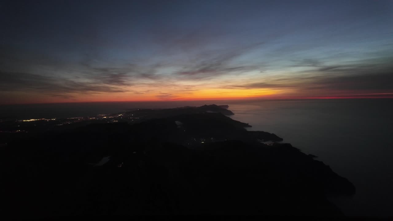 vista aérea nocturna de la isla de mallorca después de la puesta del sol, tomada desde una cabina de un avión