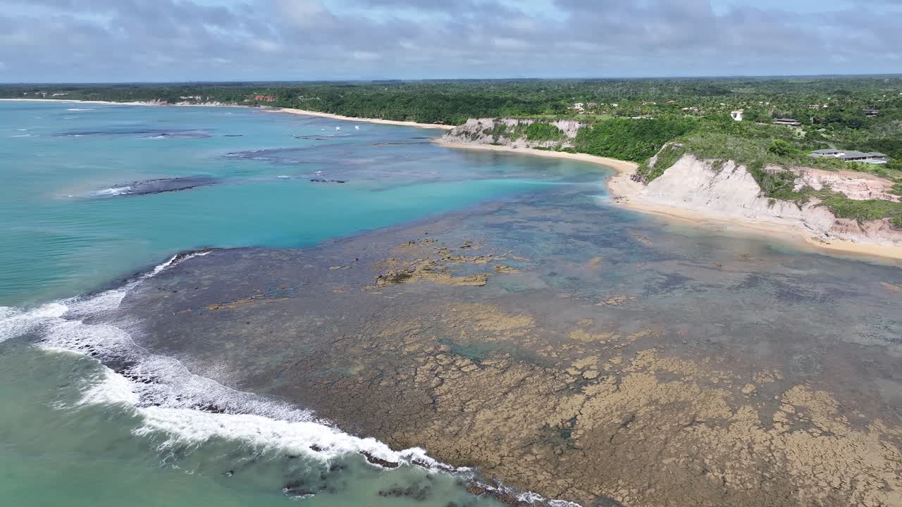 Aerial View of a Tropical Coastline with Clear Turquoise Water, Coral Reefs, and White Cliffs