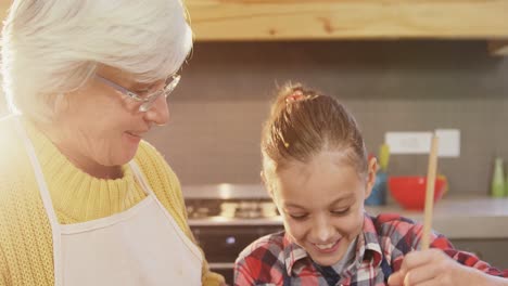Little-girl-mixing-the-batter-and-happy-grandmom-guiding-her-4K-4k