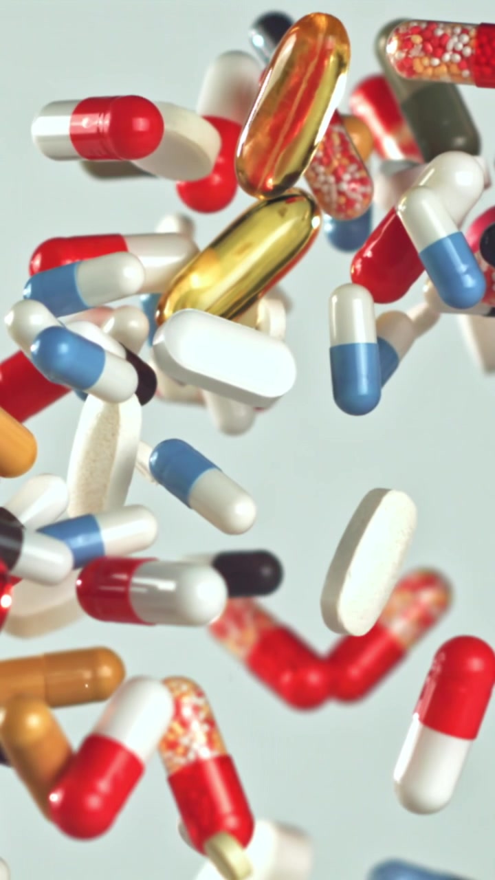 Colorful Pills and Capsules Falling in Slow Motion
