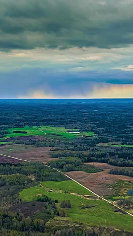 rain pouring from storm clouds in aerial timelapse over forest landscape, vertical