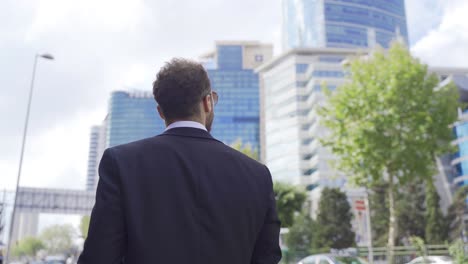 Stylish-businessman-walking-on-busy-street.