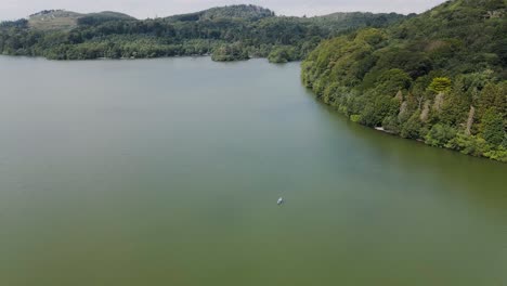 Antena-De-Inversión-E-Inclinación-De-Una-Pareja-Relajándose-En-Kayak-En-Un-Lago-Verde