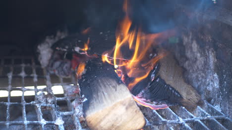 wood logs on fire in an off set smoker for bbq