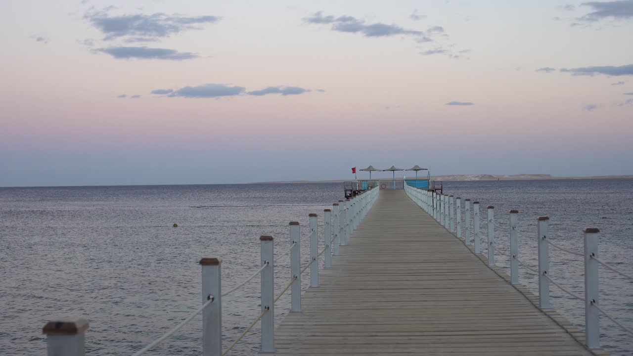 muelle en ruinas en el mar rojo. isla tiran como telón de fondo.