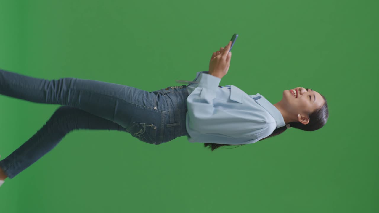 스튜디오에서 녹색 화면 배경에서 는 동안 휴대전화를 사용하는 아시아 사업가의 측면 시각