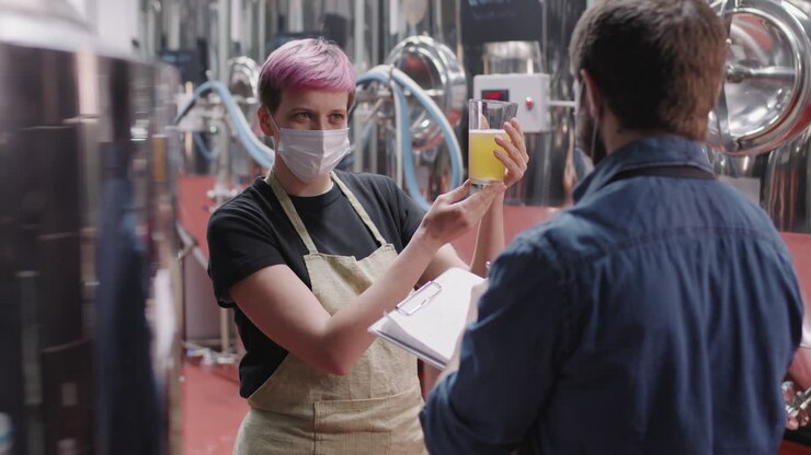 Addetti alla fabbrica di birra che testano un campione di birra