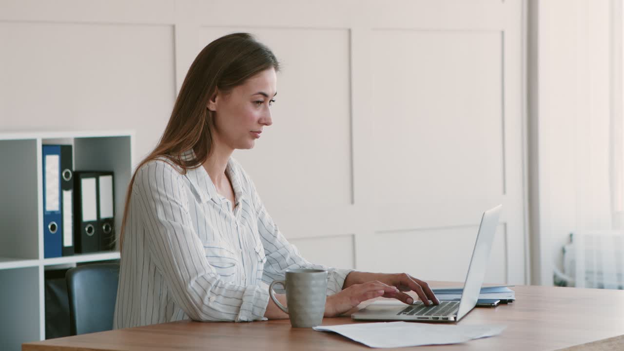 사무실에서 노트북으로 일하는 여자