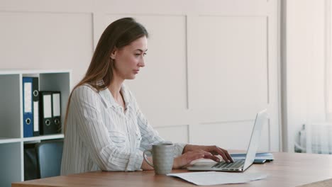 mujer trabajando en una computadora portátil en una oficina