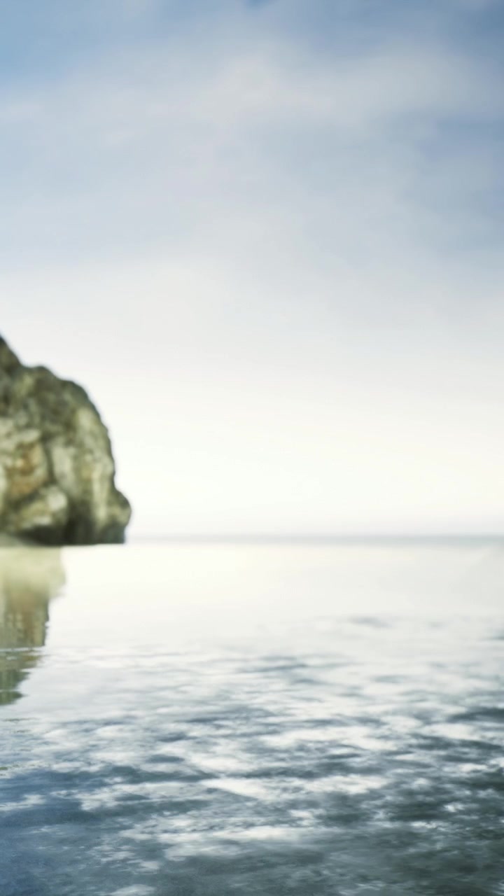 Acqua calma che riflette formazioni rocciose sulla spiaggia nel tardo pomeriggio