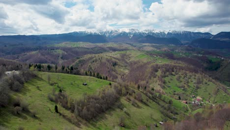 cinematic aerial view over a pittoresque mountain range with snow covered peaks in romania