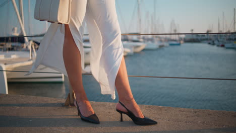 woman in stylish white dress and black heels at a marina