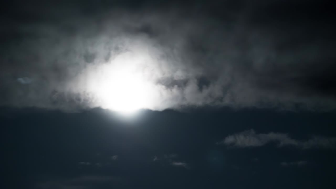 Full Moon Moves in the Night Sky through Dark Clouds. Timelapse