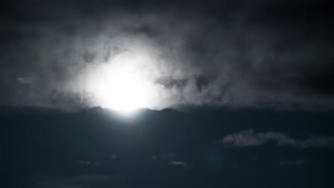 full moon moves in the night sky through dark clouds. timelapse