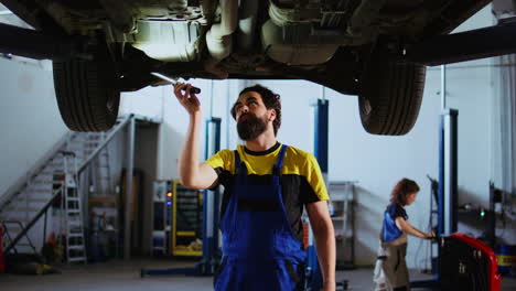 Man-in-garage-works-on-suspended-car