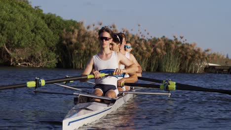 front view of male rower team rowing on the lake