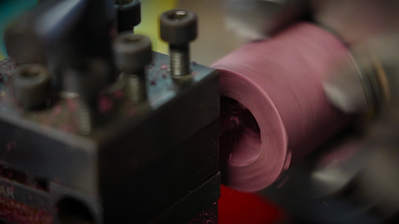 Lathe Machine Shaping A Rotating PInk Cylindrical Wood Material At Workshop. closeup shot, slowmo