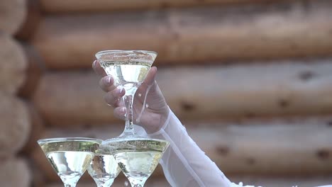 girl takes a glass of champagne from the top of a glass of glasses of champagne