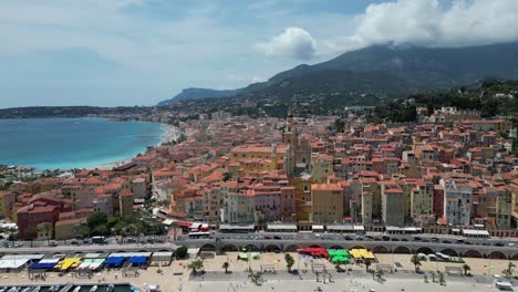 plage des sablettes beach in menton france and old town with saint michel basilica, aerial approach shot