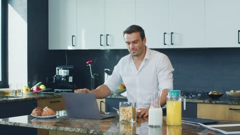 Business-man-talking-at-computer-in-kitchen.-Closeup-person-having-online-chat.