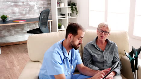 male nurse holding tablet computer in retirement home