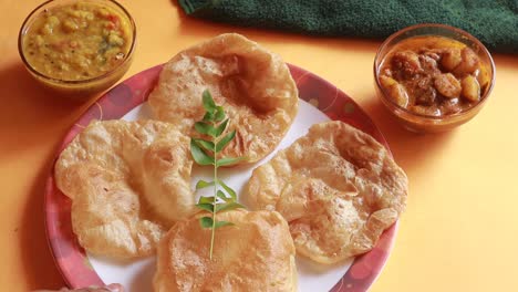 rotation-Chole-Bhature-or-Chick-pea-curry-and-Fried-Puri-served-in-terracotta-crockery-over-yellow-background