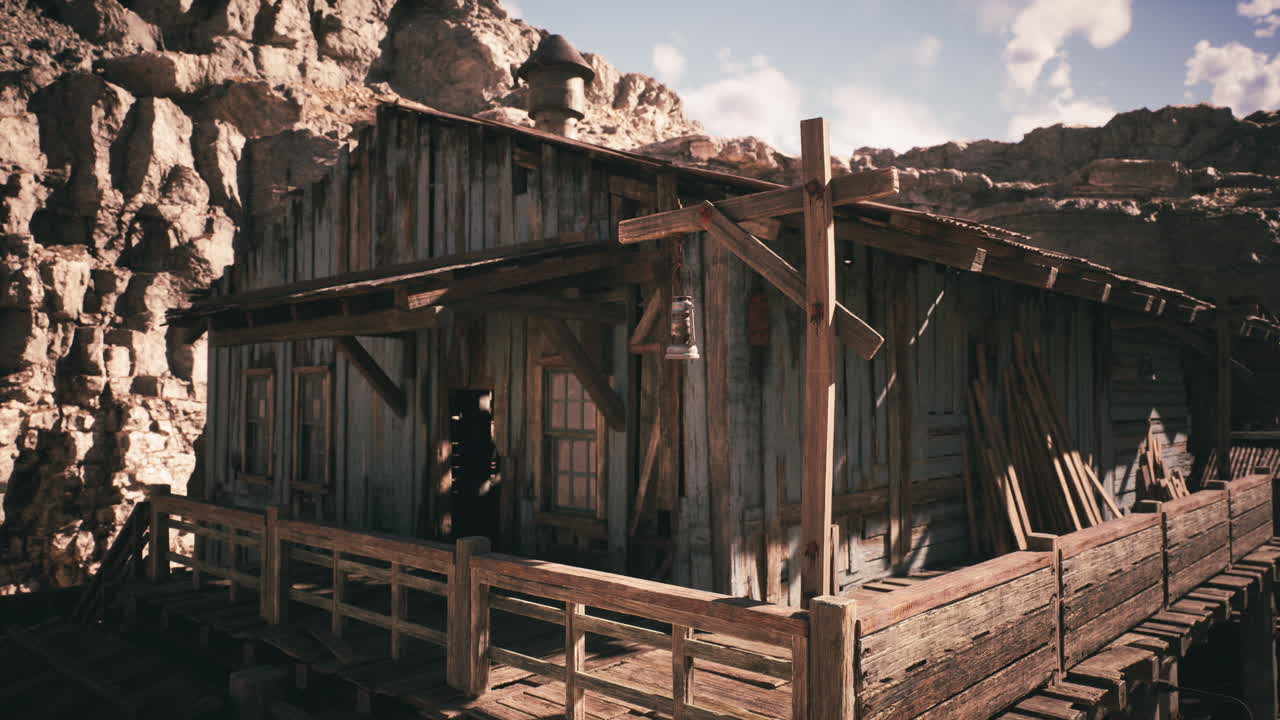 A rustic wooden cabin surrounded by rocky cliffs during a sunny day