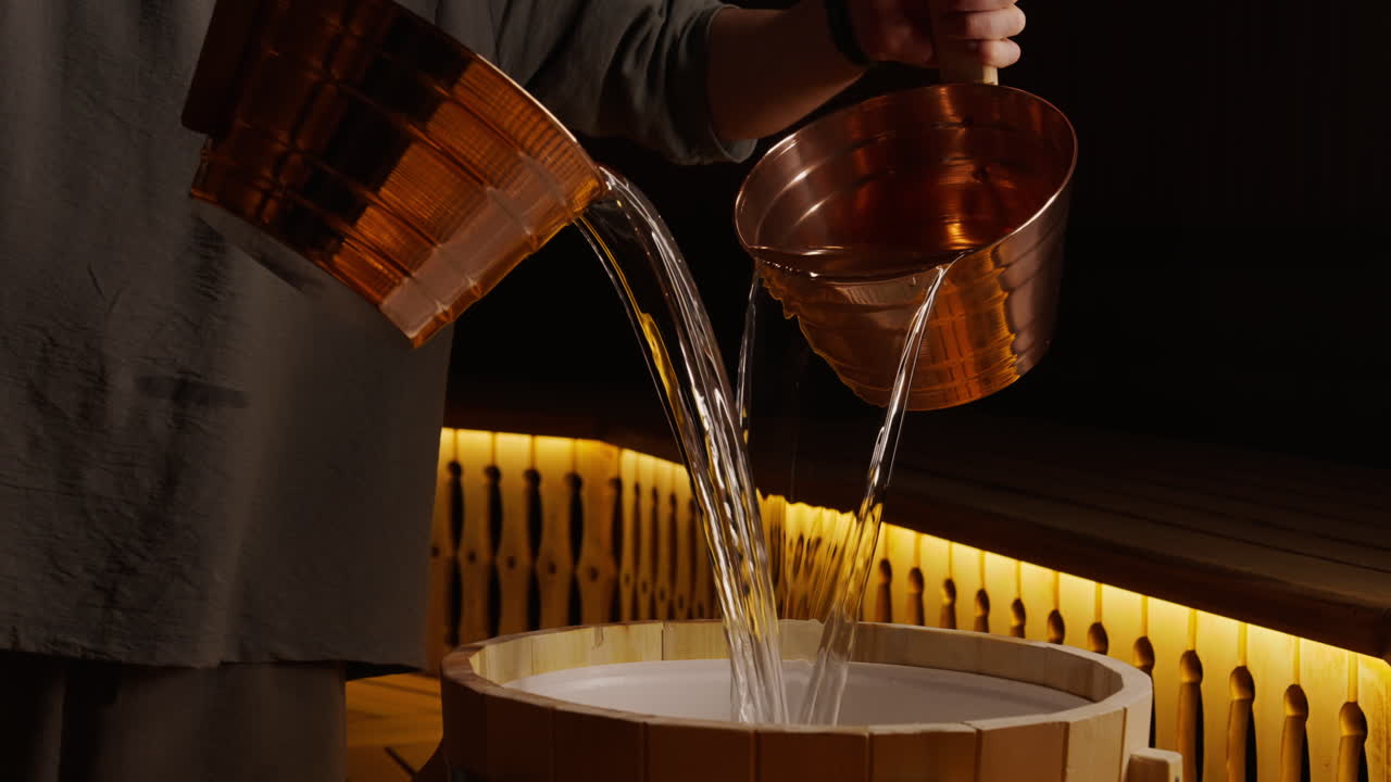 Pouring Water into a Sauna Barrel
