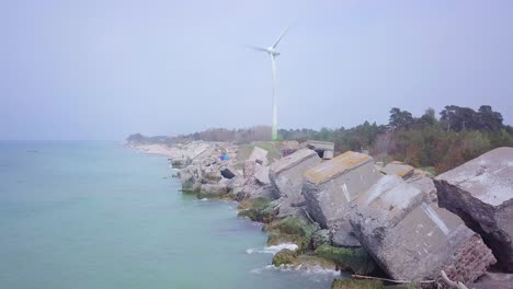 aerial view of abandoned seaside fortification buildings at karosta northern forts on the beach of baltic sea in liepaja, latvia, calm sea on a sunny day, wide angle drone shot moving backward