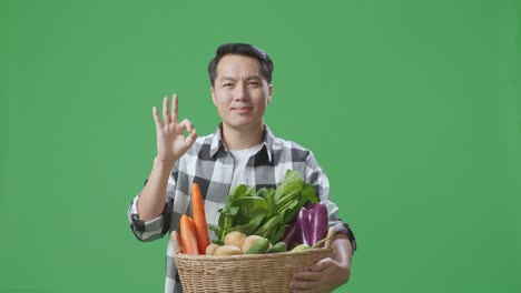 hombre sosteniendo una canasta de verduras frescas