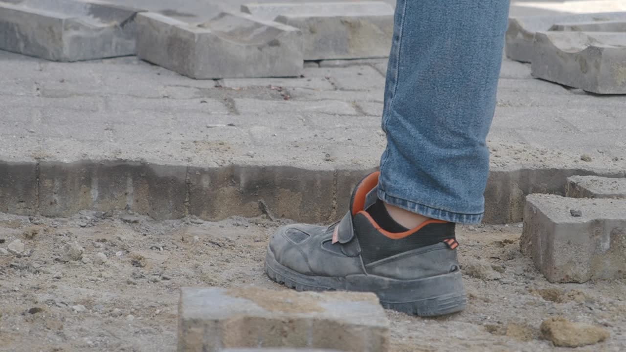 Construction worker laying pavers