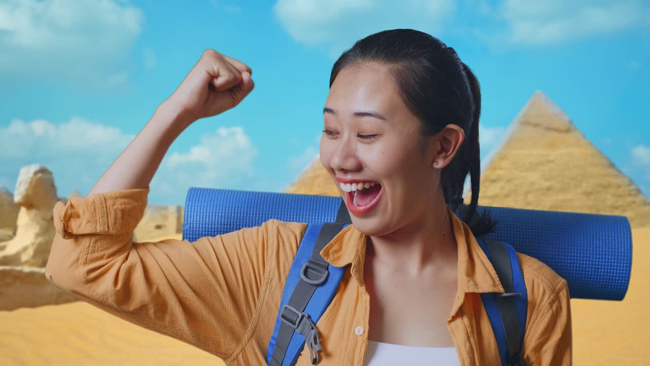 Close Up Of Asian Female Hiker With Mountaineering Backpack Smiling And Flexing Her Bicep While Traveling In Pyramid Of Giza