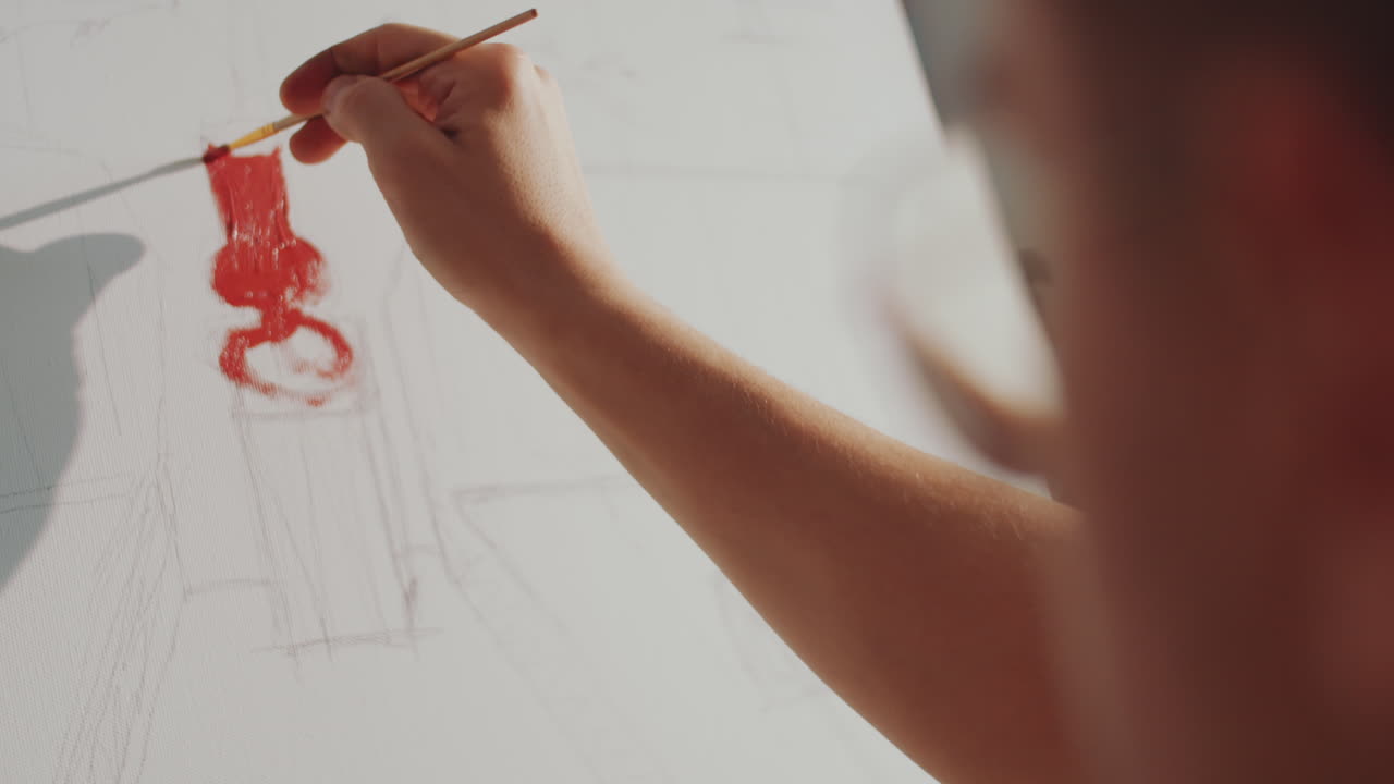 남성 예술가 가 연필 그림 에 컬러 페인트 를 첨가 하고 있다