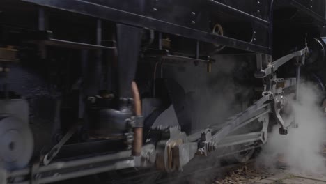 primer plano de ruedas de locomotoras de vapor y pistones en movimiento