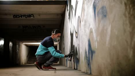 graffiti artist painting on the wall in subway