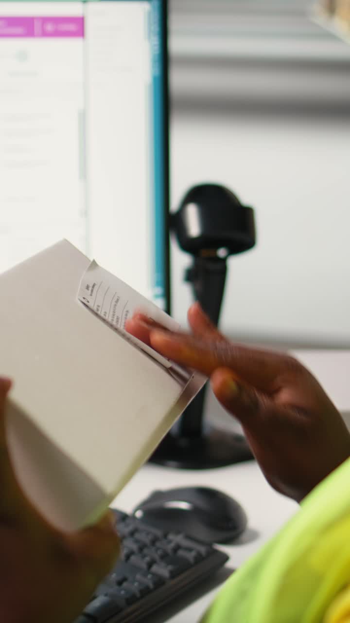 Vertical Video Black woman packing goods and applying shipping labels on boxes