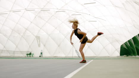 WIDE-SIDE-VIEW-Young-Caucasian-female-tennis-player-hitting-a-ball-during-game-or-practice.-100-FPS-slow-motion,-4K-UHD-RAW-graded-footage