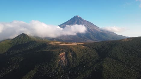 Slow-reversing-clip-of-volcanic-Taranaki-Mountain-partly-covered-in-thick-white-clouds