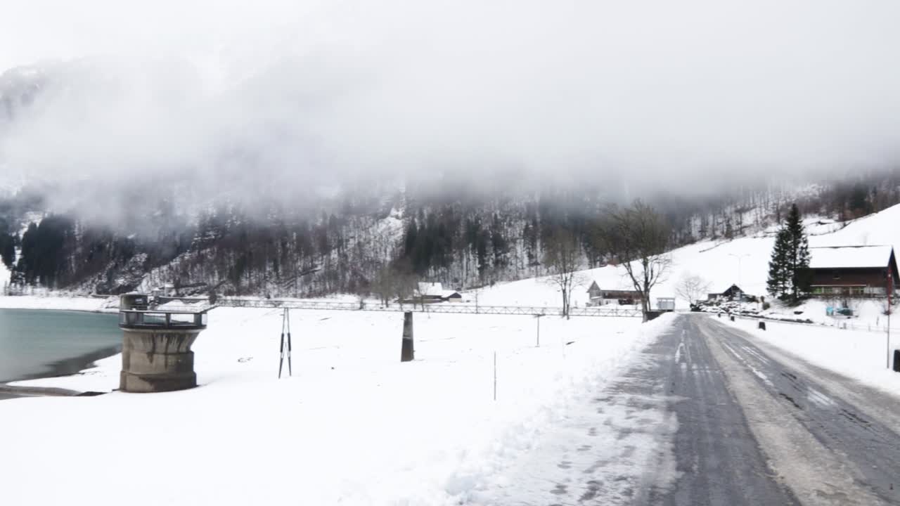 겨울 동안 스위스 글라루스에서 낮은 구름이 있는 얼어붙은 klontalerstrasse 호수의 전망