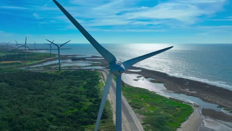 aerial orbit close up of wind turbine at coastline of taiwan