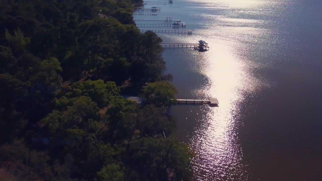드론이 해안선을 따라 극적으로 날아가 물 위의 아름다운 집을 드러냅니다.