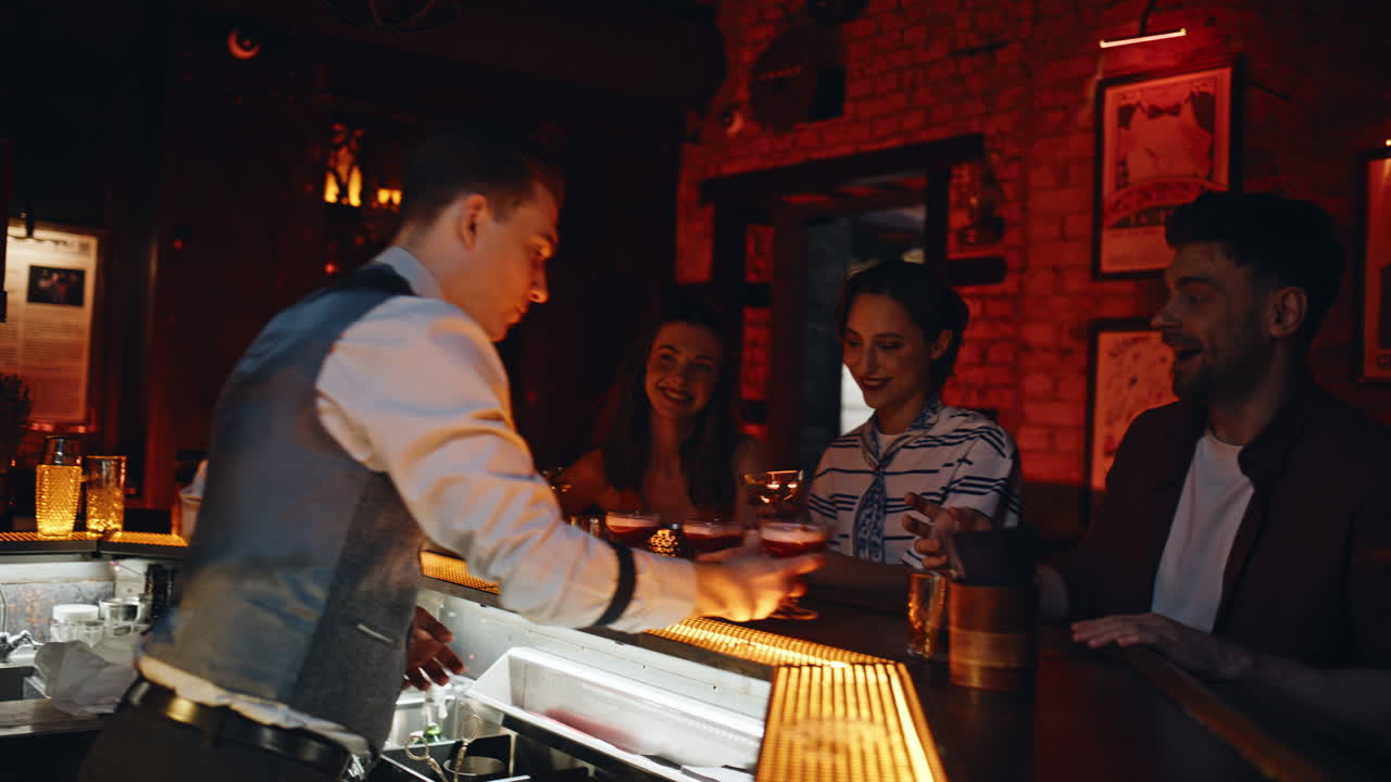 Bartender attento serve i clienti in un bar notturno, primo piano. Lavoratore professionista