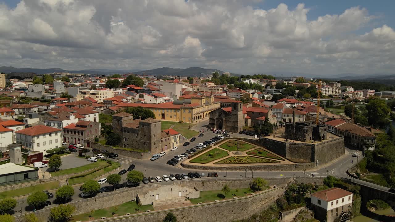 aerial - historic Barcelos walled town and Cávado River under partly cloudy skies